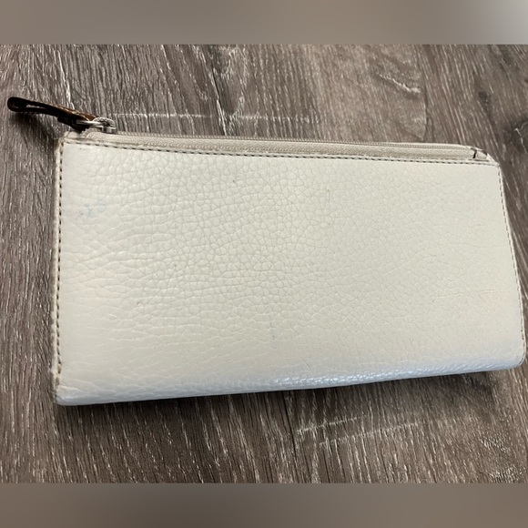 White ‘Coach’ brand wallet. Brown interior. Scuffs and marks on edges of wallet. - Picture 2 of 5